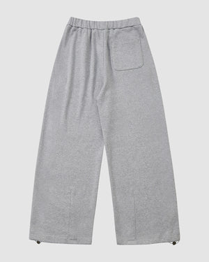 The Sundae School HEATHER GREY WRAP SWEATBAJI are loose-fitting, unisex cotton pants in gray, featuring an elastic waistband, right back pocket, and Hanbok-inspired drawstring cuffs, shown laid flat on a white background.