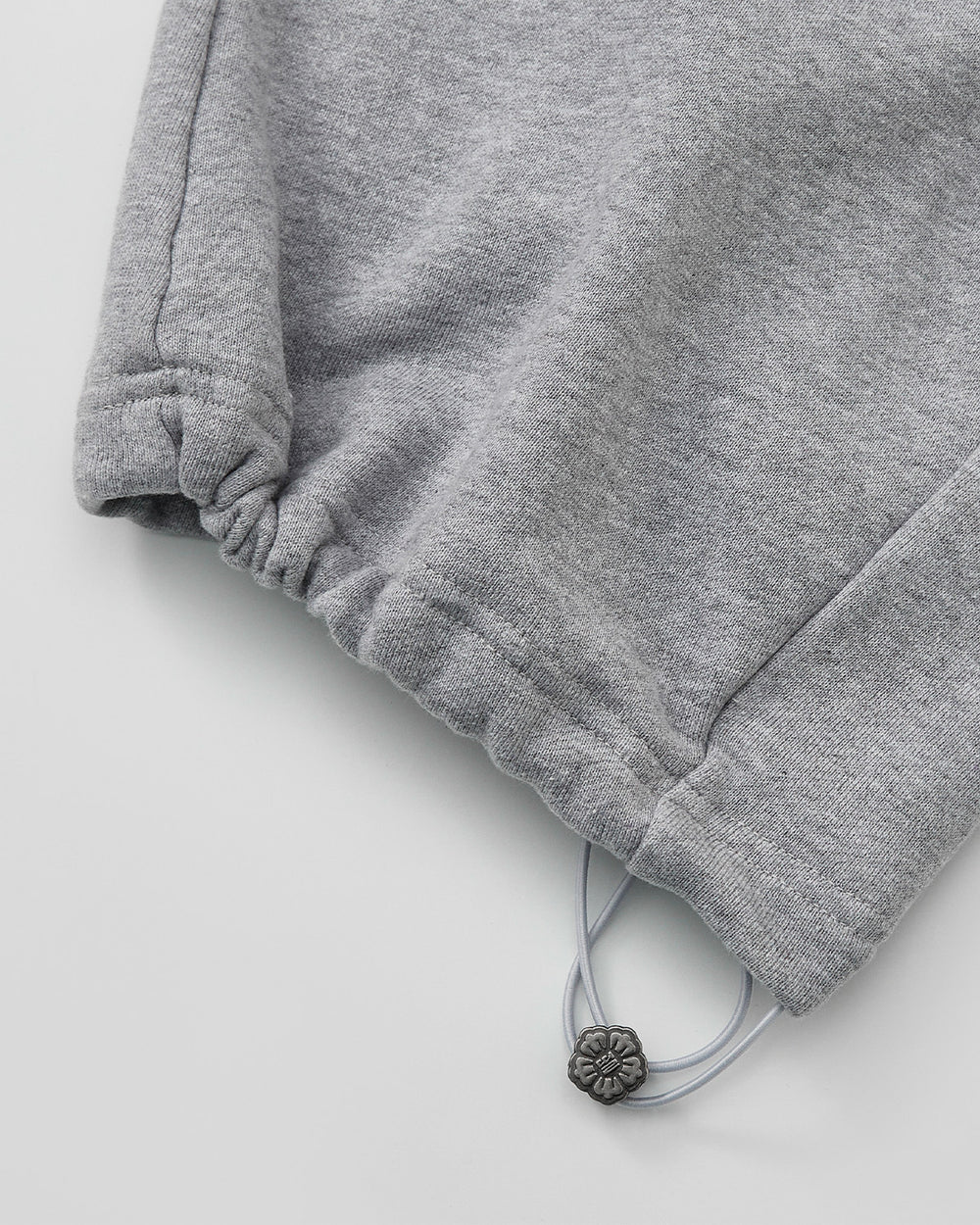Close-up of the HEATHER GREY WRAP SWEATBAJI by Sundae School, featuring an elastic cuff and adjustable drawstring with a silver bead—ideal for pairing with unisex cotton pants or wide leg sweatpants for maximum comfort.