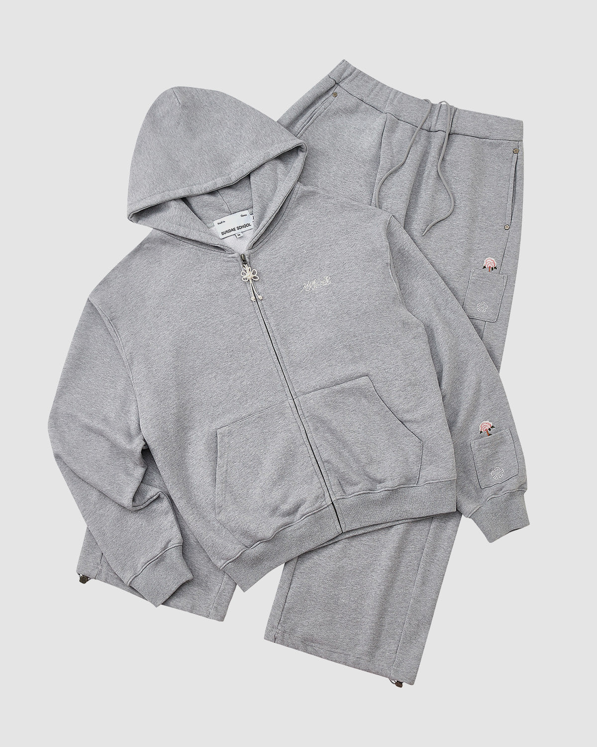 The Sundae School HEATHER GREY WRAP SWEATBAJI is a heather gray tracksuit set with a zip-up hoodie and Hanbok-inspired wide leg sweatpants, featuring small embroidered details, shown against a plain white background.