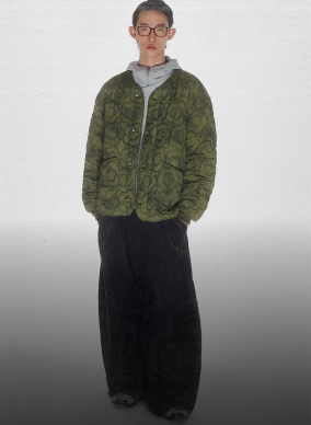 A model wearing Sundae School Matcha Mochi Quilted Military Liner and Sundae School x Jooniverse pants agaisnt a white background. 