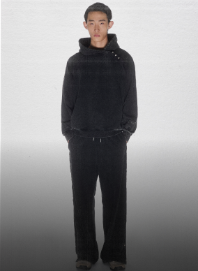 A male model wearing Sundae School Fade Black Hanbok Hoodie and Fade Black Hanbok Snap pants. 