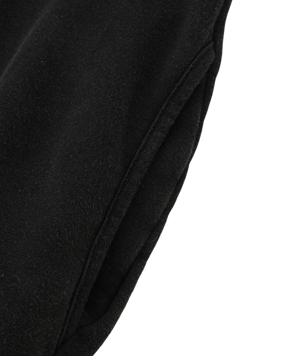 Close-up of the BLACK WASH HANBOK HOODIE by Sundae School, featuring black textured fabric with visible seaming and a pocket—evoking the feel of a classic cotton sweatshirt. The design nods to cozy oversized hoods, merging comfort with contemporary style.