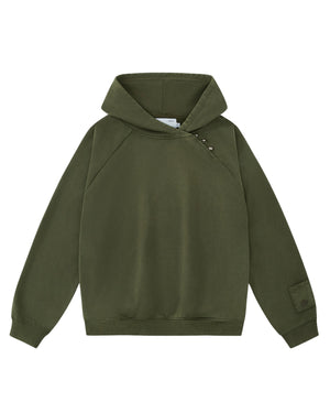 The KHAKI HANBOK HOODIE by Sundae School is an olive green hooded sweatshirt with long sleeves, featuring an asymmetric hood closure with snap buttons on the right shoulder and a patch on the left sleeve. This custom “떨” logo hoodie also includes a signature sleeve stash pocket, and is shown laid flat on a white background.