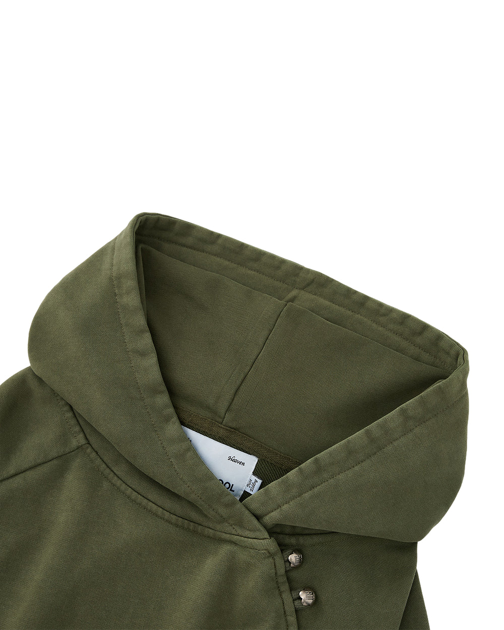Close-up of the Sundae School KHAKI HANBOK HOODIE, a custom olive green hoodie featuring an asymmetric hood closure with metal snap buttons near the neckline and a white label partially visible inside the hood. The soft, slightly structured fabric complements its modern design, while the signature sleeve stash pocket provides a subtle yet functional detail.