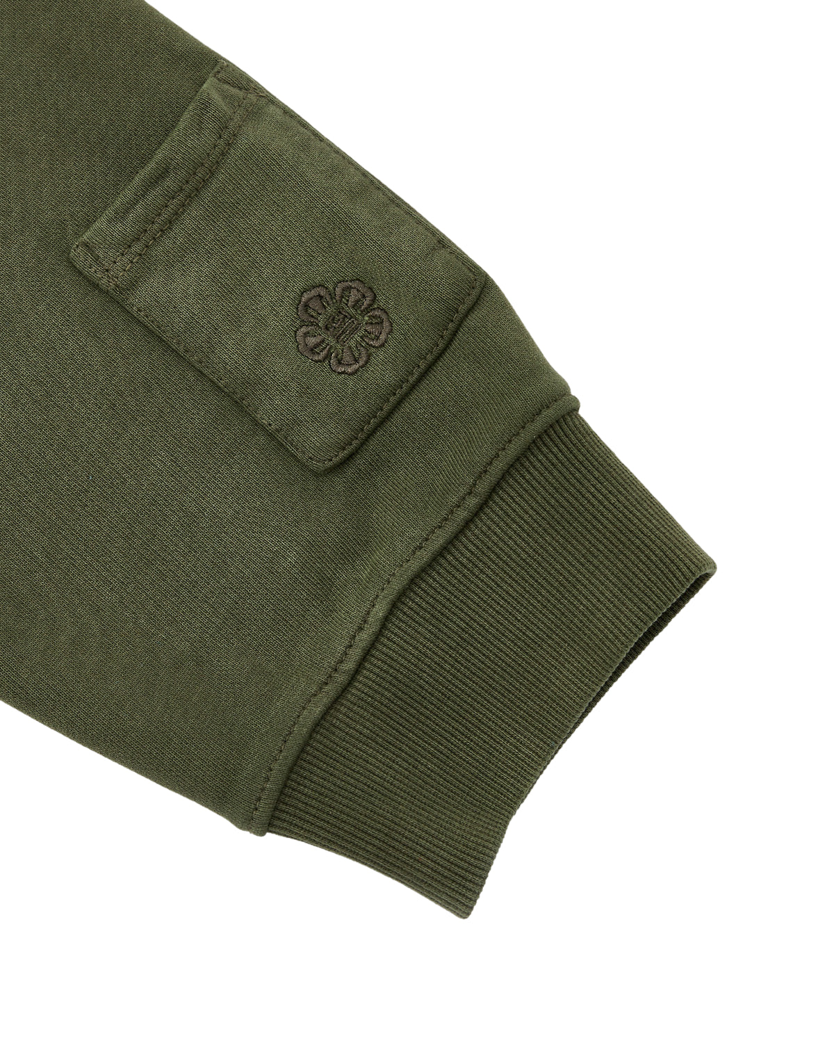 A close-up of the KHAKI HANBOK HOODIE by Sundae School shows an olive green sleeve with a ribbed cuff and a signature sleeve stash pocket adorned with an embroidered flower design.