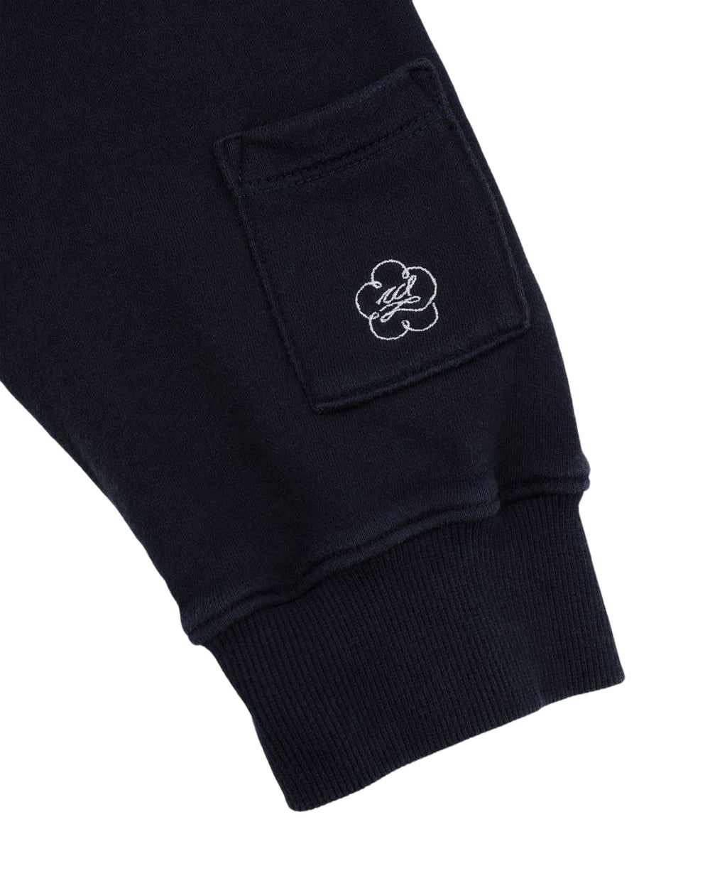 The image displays the cuff and lower sleeve of a Sundae School NAVY WASH HANBOK HOODIE, showcasing a small pocket adorned with an embroidered flower and initials within the design, crafted from custom cotton.
