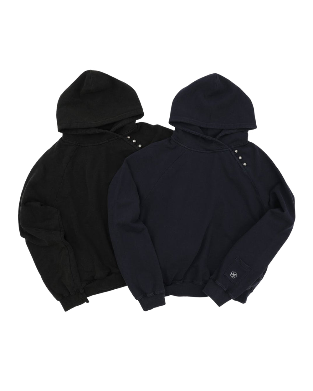 Two hooded sweatshirts from Sundae School are laid flat side by side—one in black and one in dark navy. Both feature an oversized hood, snap buttons at the collar, and long sleeves made from custom cotton fabric. On the NAVY WASH HANBOK HOODIE, a small white symbol appears near the cuff.