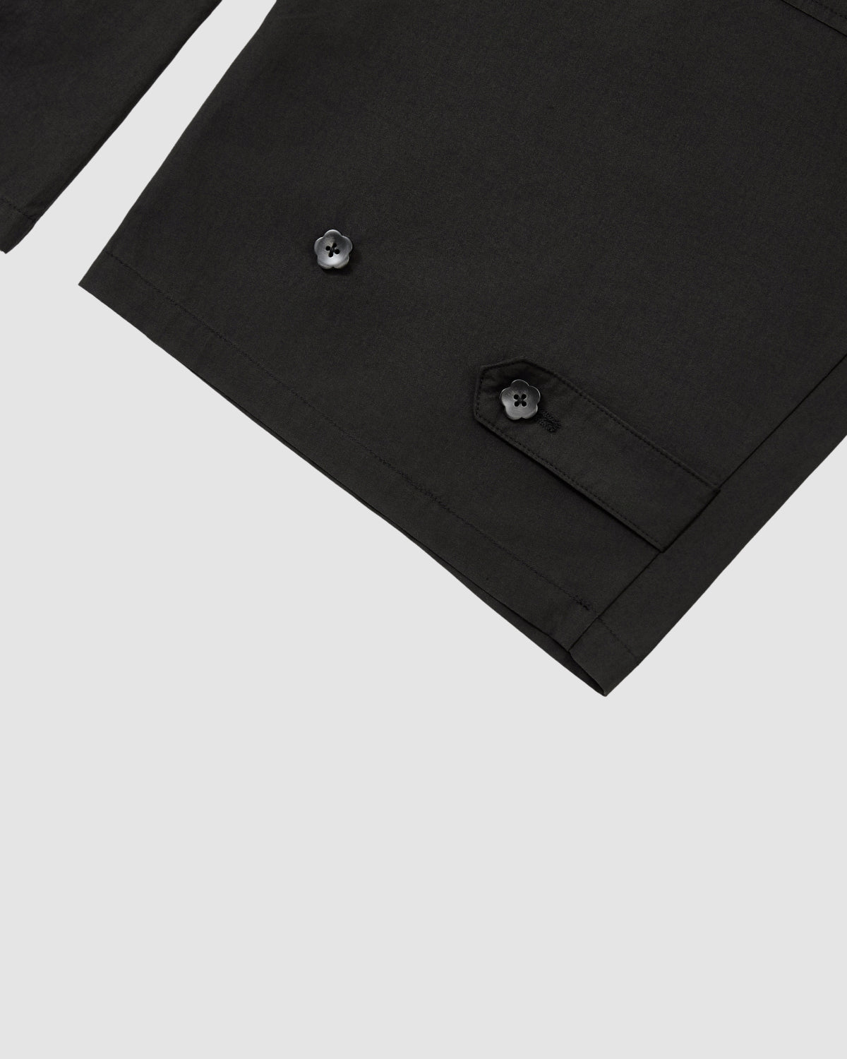 Close-up of Sundae School's BLACK HANBOK LINEN PANTS, featuring two black buttons and a flap detail, displayed against a light grey background.