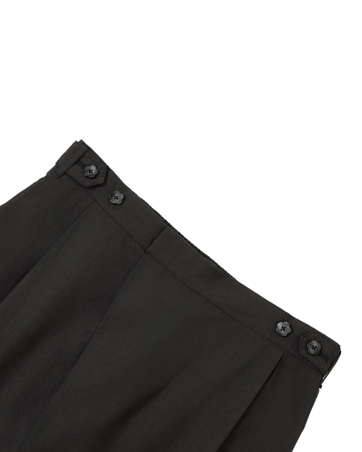 Close-up of the waistband of the BLACK HANBOK LINEN PANTS by Sundae School, highlighting an adjustable waist with two black buttons on each side near the top edge, set against a white background. These cotton-linen pants feature a relaxed fit and wide barrel leg design for comfortable styling.