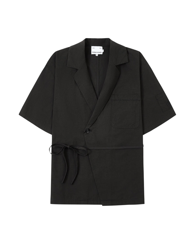 The BLACK HANBOK LINEN SHIRT by Sundae School is a black, short-sleeve blazer-style jacket inspired by the cotton linen hanbok, featuring a chest pocket, side tie closure, single button, and notched lapels, laid flat on a white background.