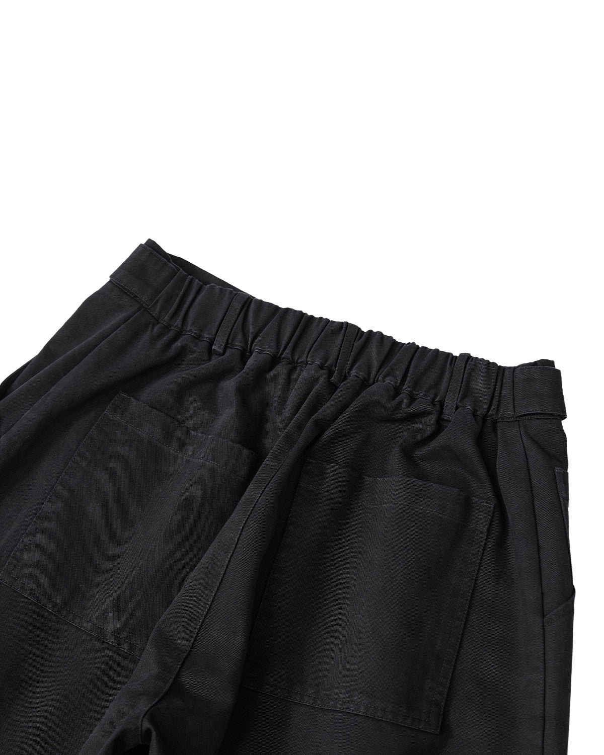 The BLACK HANBOK CHINO PANTS by Sundae School are made from black washed cotton with an elastic waistband and two oversized back pockets, featuring a relaxed barrel-fit silhouette. They are shown from the back against a white background.