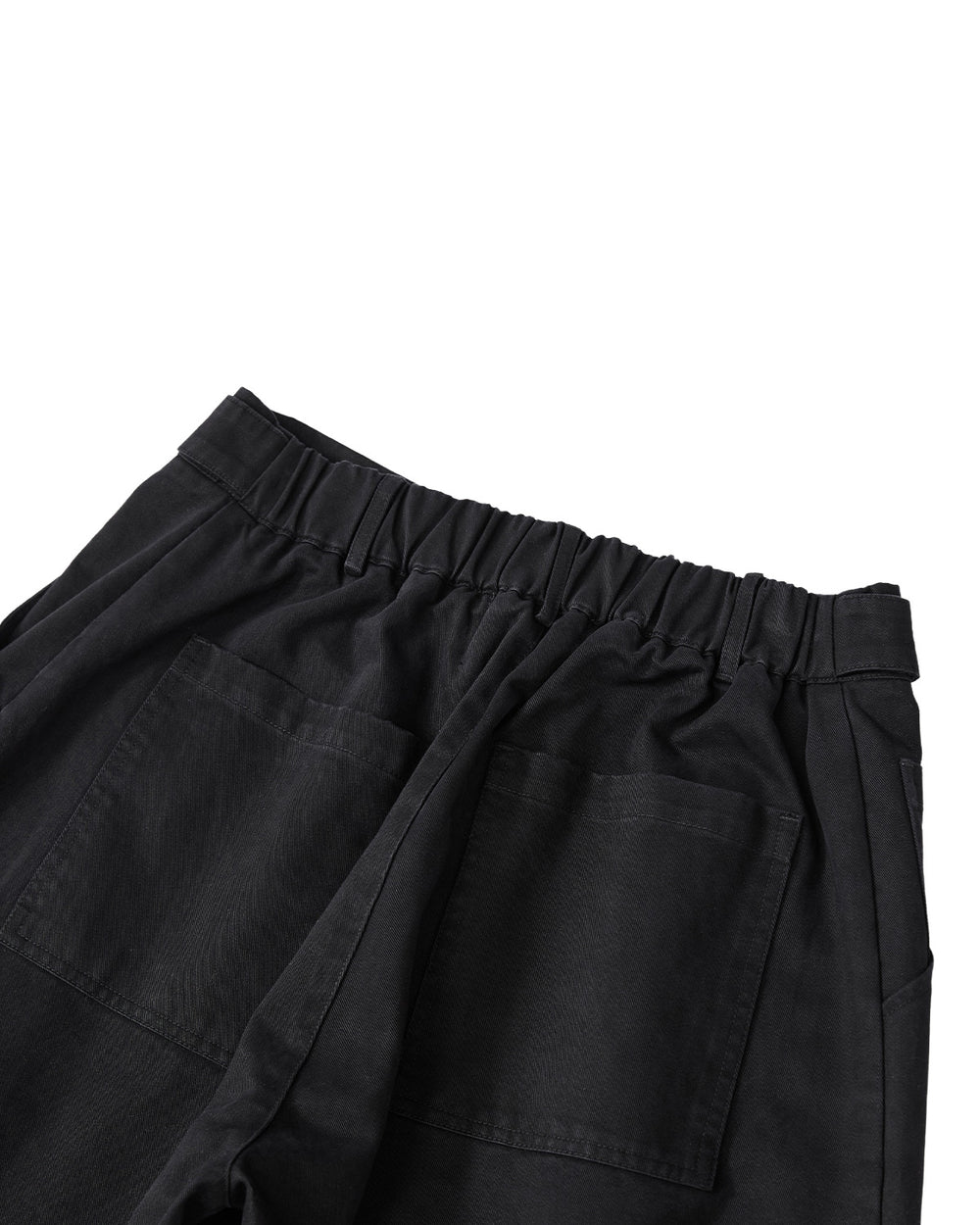 The BLACK HANBOK CHINO PANTS by Sundae School are made from black washed cotton with an elastic waistband and two oversized back pockets, featuring a relaxed barrel-fit silhouette. They are shown from the back against a white background.