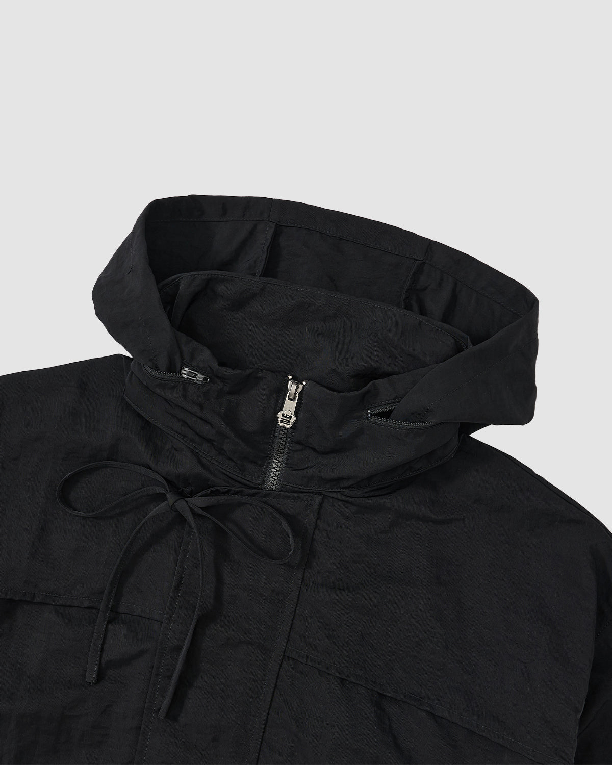 A close-up of the BLACK HANBOK TRACK JACKET by Sundae School, featuring a half-zip front and neck drawstrings, displayed against a light gray background.
