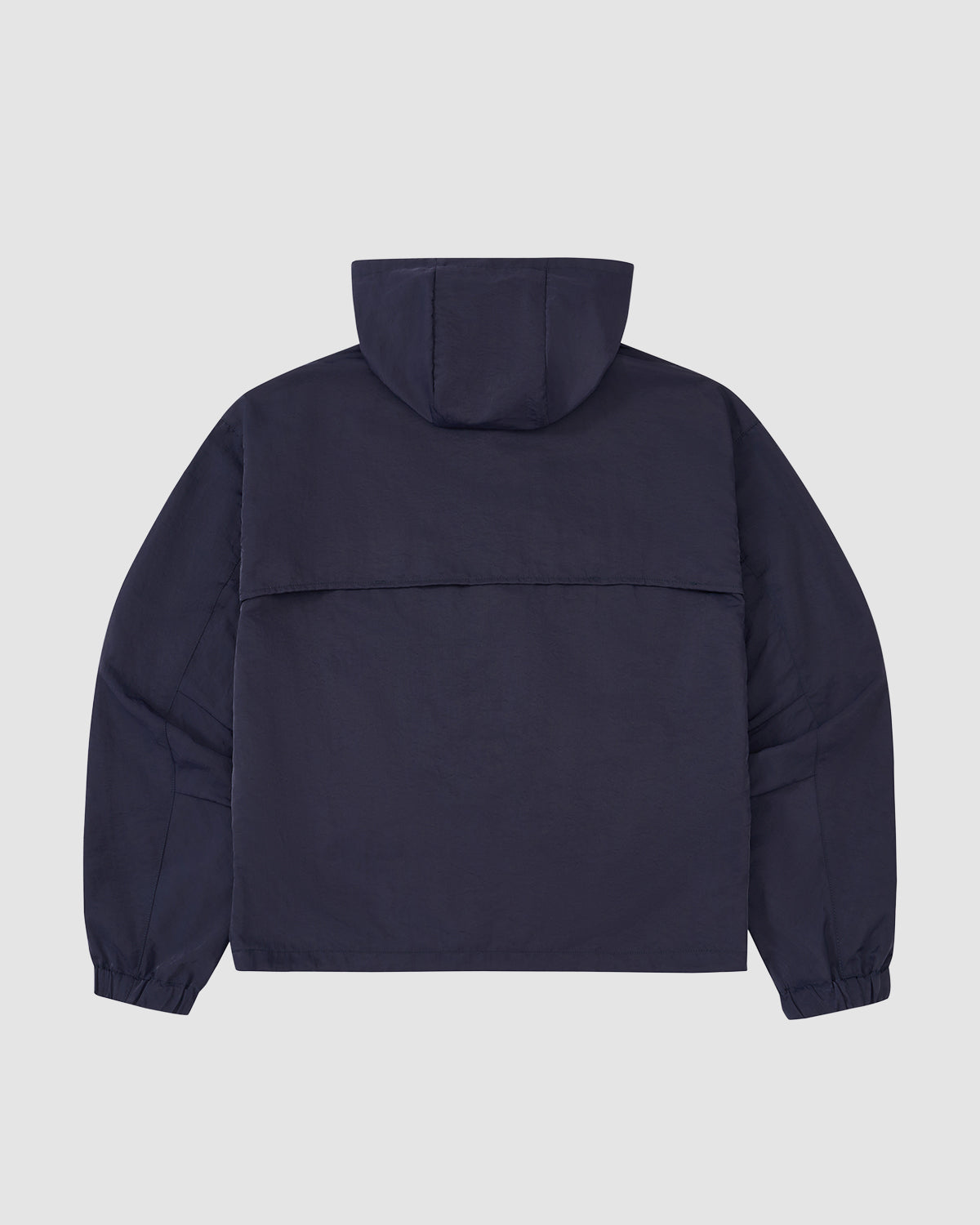 The Sundae School NAVY HANBOK TRACK JACKET is shown from the back, featuring long sleeves, elastic cuffs, a relaxed fit, and lightweight nylon construction with a minimalist design and no visible logos or embellishments.
