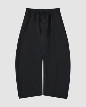 The BLACK HANBOK BALLOON TRACK PANTS by Sundae School feature a wide-leg fit, drawstring waist, vertical seams, and technical nylon fabric for windproof and water-resistant performance.