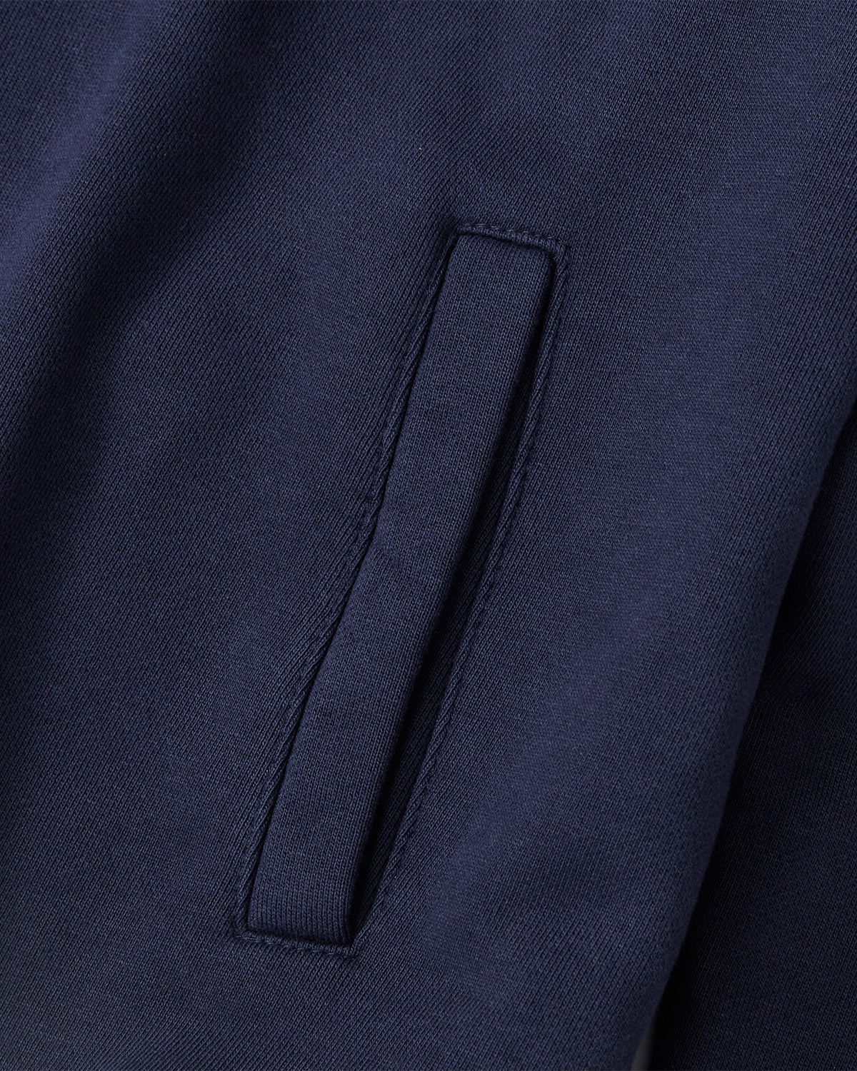 Close-up of the Sundae School NAVY HESTER QUARTER ZIP, a vintage-inspired pullover with a rectangular stash pocket. Crafted from smooth cotton fabric, it features a subtle woven texture for added style.