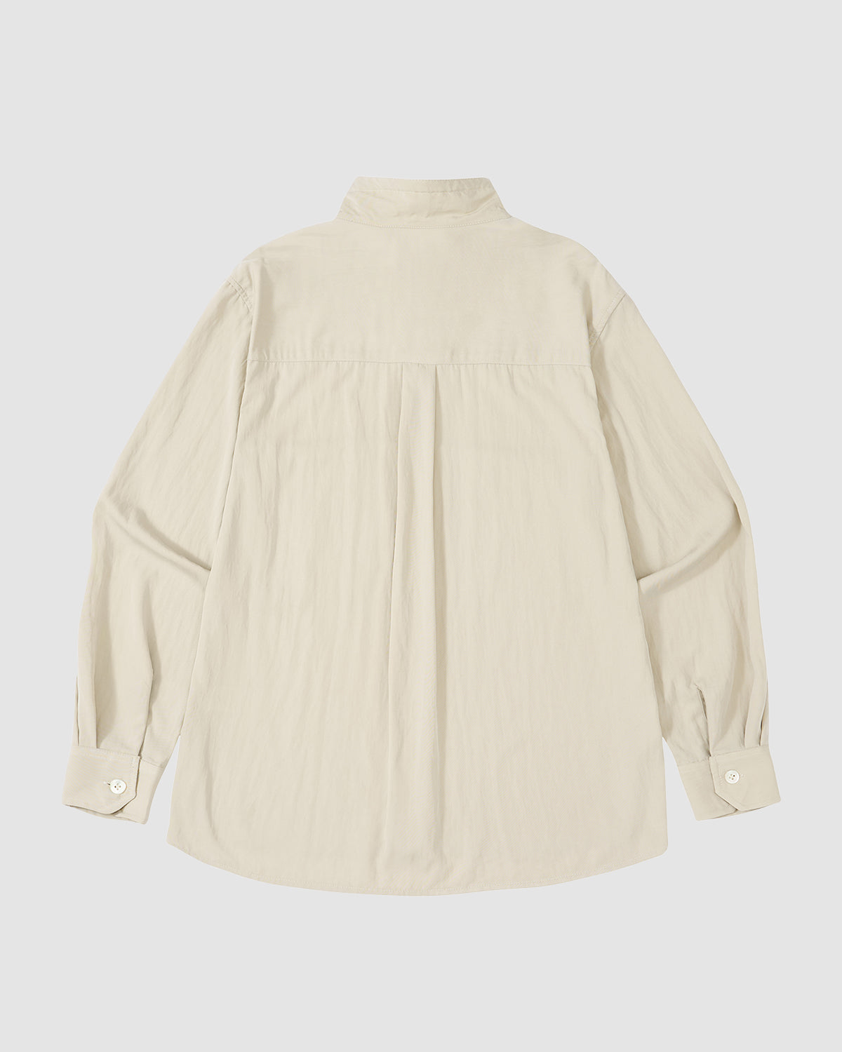 The Sundae School IVORY HIGH NECK TIE SHIRT is shown from the back with a yoke, center pleat, buttoned cuffs, and oversized chest pockets. Its summer-weight fabric provides comfort and style.