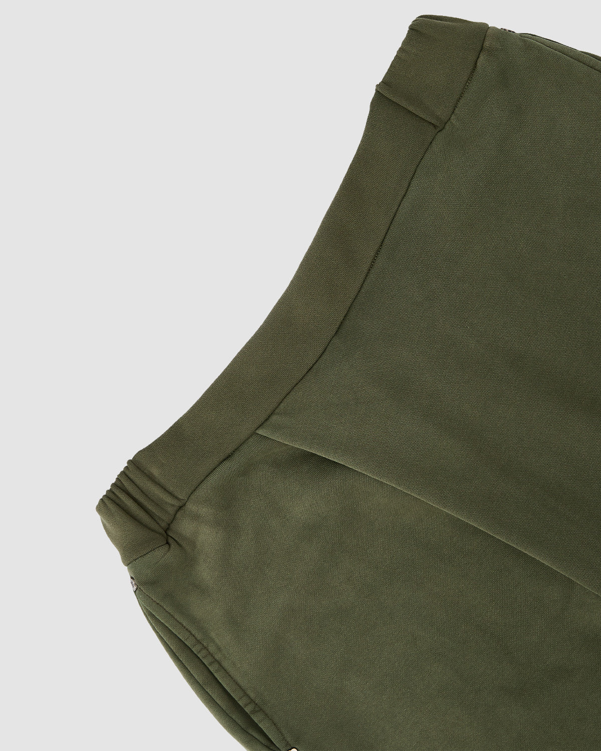 Close-up of the waistband and upper section of Sundae School's KHAKI WRAP SWEATBAJI, showcasing smooth khaki fabric, subtle seam accents, and an elasticated back panel inspired by Hanbok design.