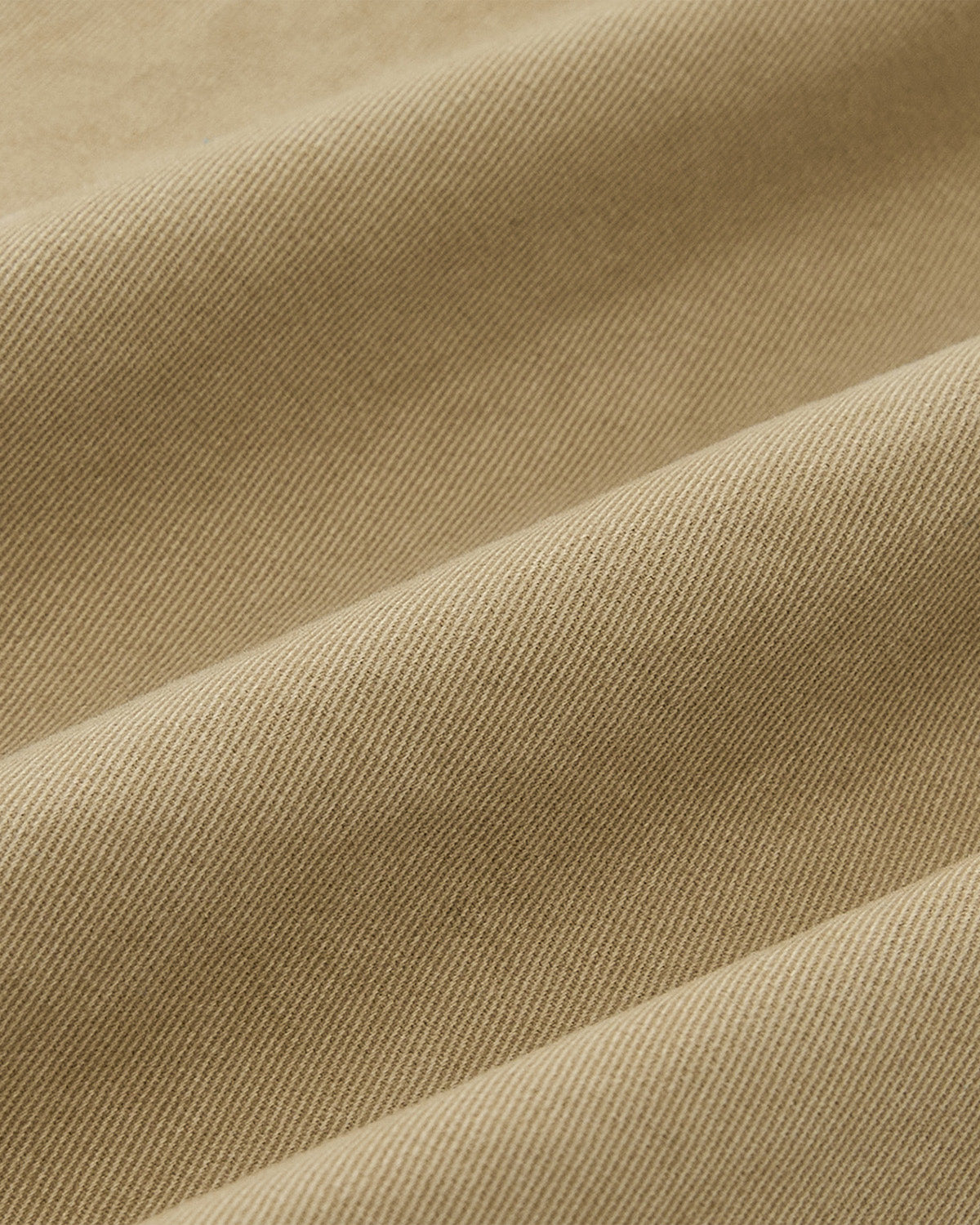 Close-up of beige fabric with diagonal ribbing and gentle folds, ideal for Sundae School's OLIVE HANBOK CHINO PANTS—relaxed, modern barrel-fit chinos inspired by traditional design.