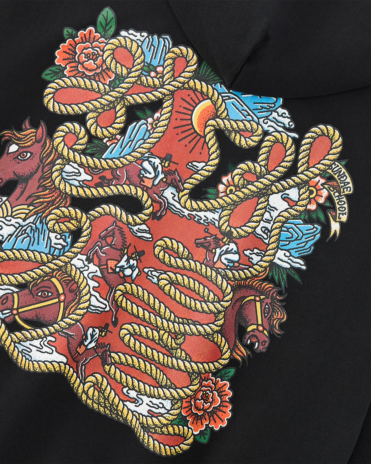 The HIGH HORSE LNY HOODIE by Sundae School features a vibrant illustration of horses, flowers, clouds, and sun in bold reds, blues, yellows, and greens—intertwined with golden ropes on a black background.
