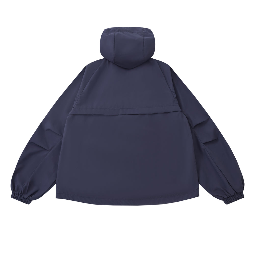 The NAVY JEOGORI TIE SHELL JACKET by Sundae School is a unisex technical outerwear piece in navy blue, featuring a water-resistant shell, elastic cuffs, long sleeves, and a relaxed fit. Shown from the back against a plain light background.