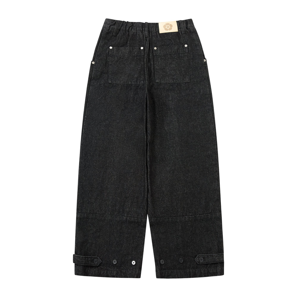Black wide-leg denim pants with an elastic waistband, front patch pockets, and buttoned cuff tabs, shown flat on a white background.