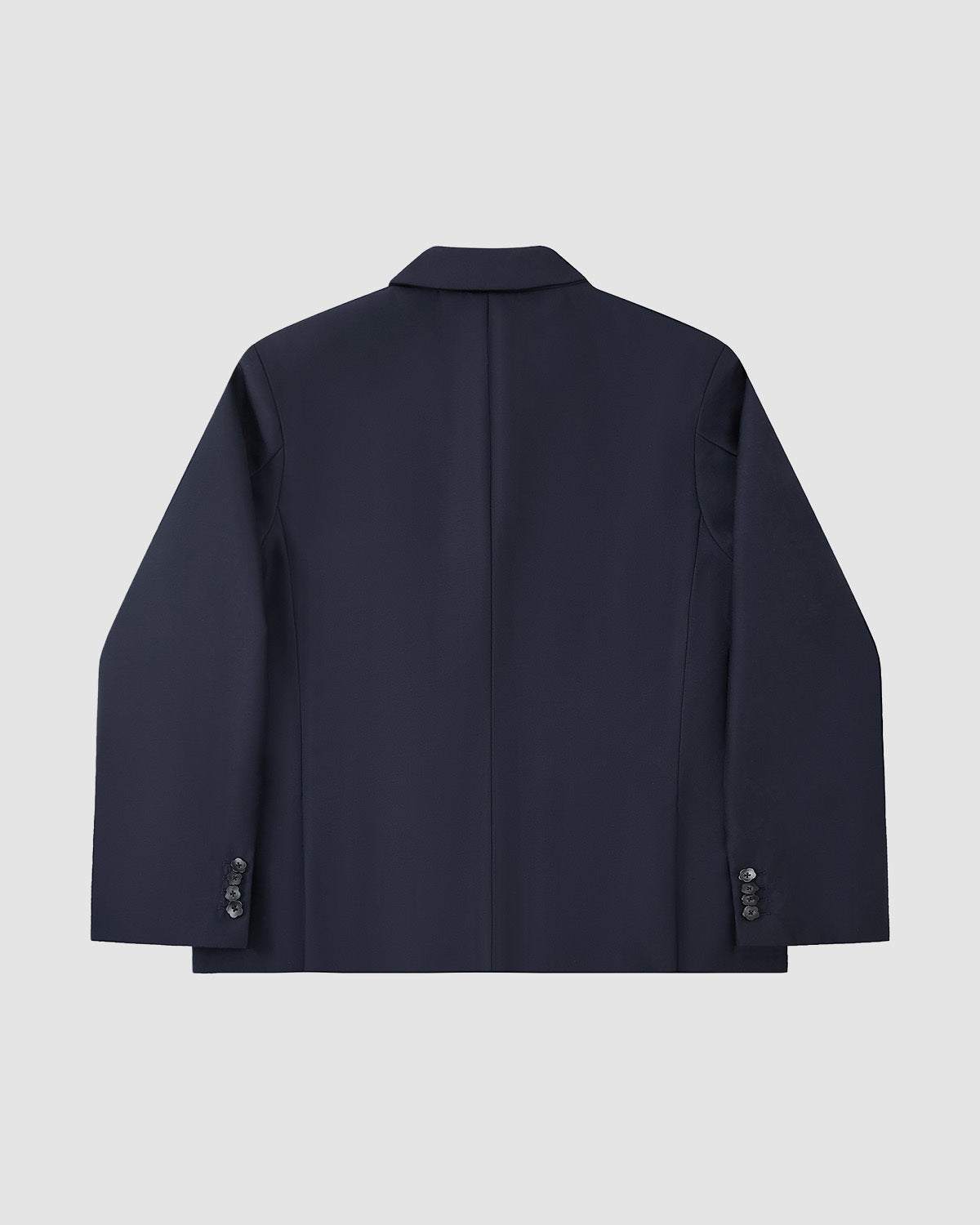 The Sundae School NAVY DOUBLE DUTY BLAZER, a navy wool blend with long sleeves, cuff buttons, and a subtle hanbok silhouette, is shown from the back against a plain light gray background.