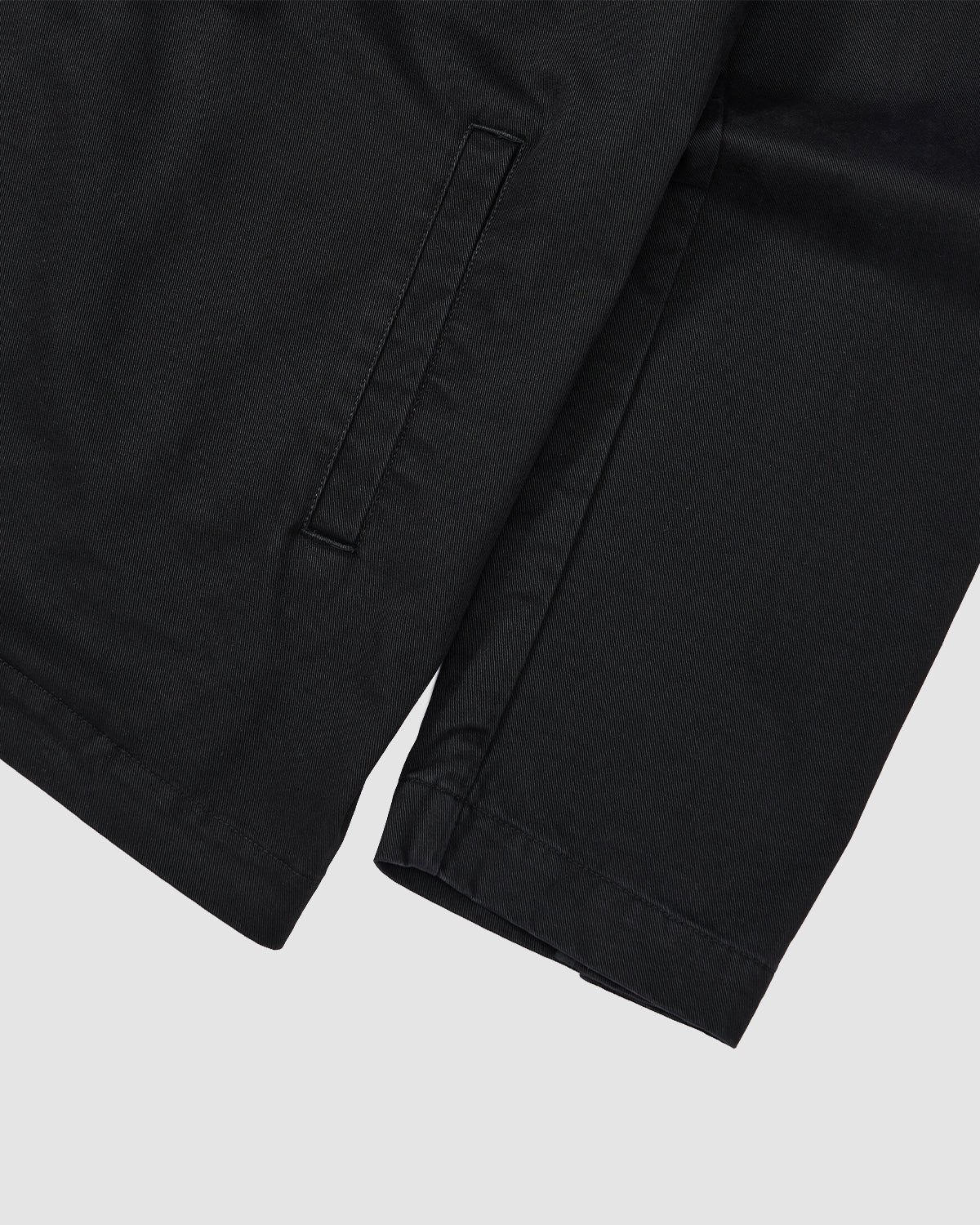 Close-up of the sleeve and pocket on the BLACK JEOGORI TIE JACKET by Sundae School, featuring a smooth fabric and simple horizontal slit pocket, with a subtle Jeogori silhouette against a light gray background.