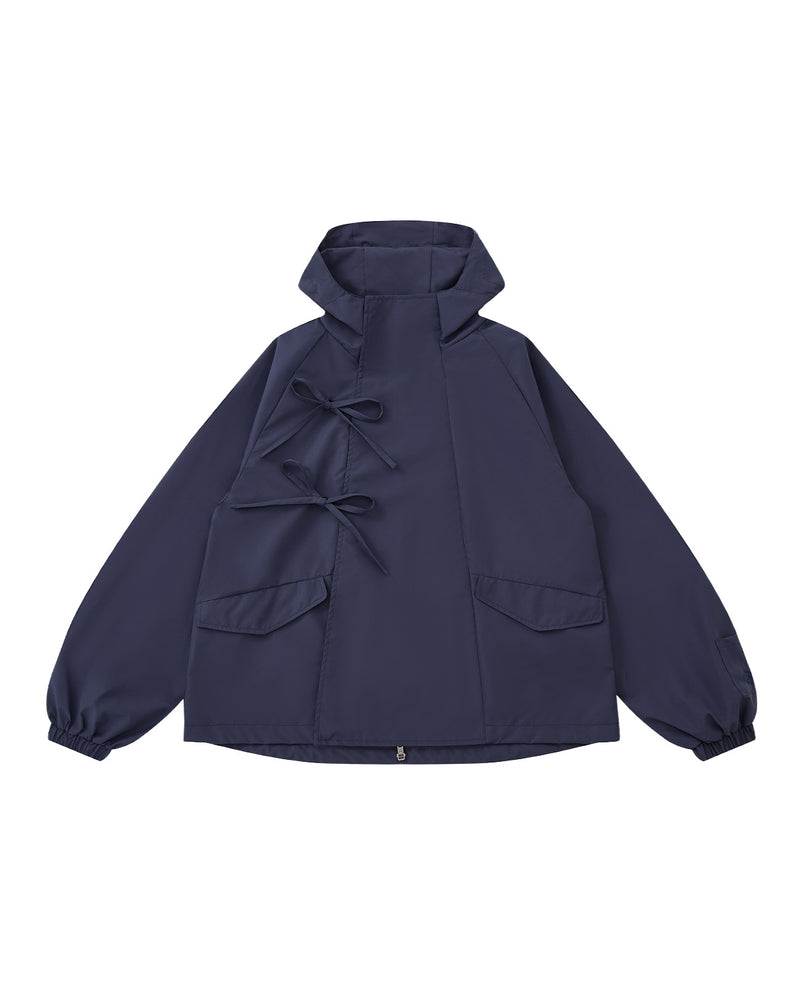 The Sundae School NAVY JEOGORI TIE SHELL JACKET features a water-resistant navy shell, two front pockets, elastic cuffs, and dual bow tie closures, shown against a plain light gray background.
