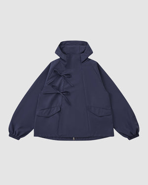 The Sundae School NAVY JEOGORI TIE SHELL JACKET features a water-resistant navy shell, two front pockets, elastic cuffs, and dual bow tie closures, shown against a plain light gray background.
