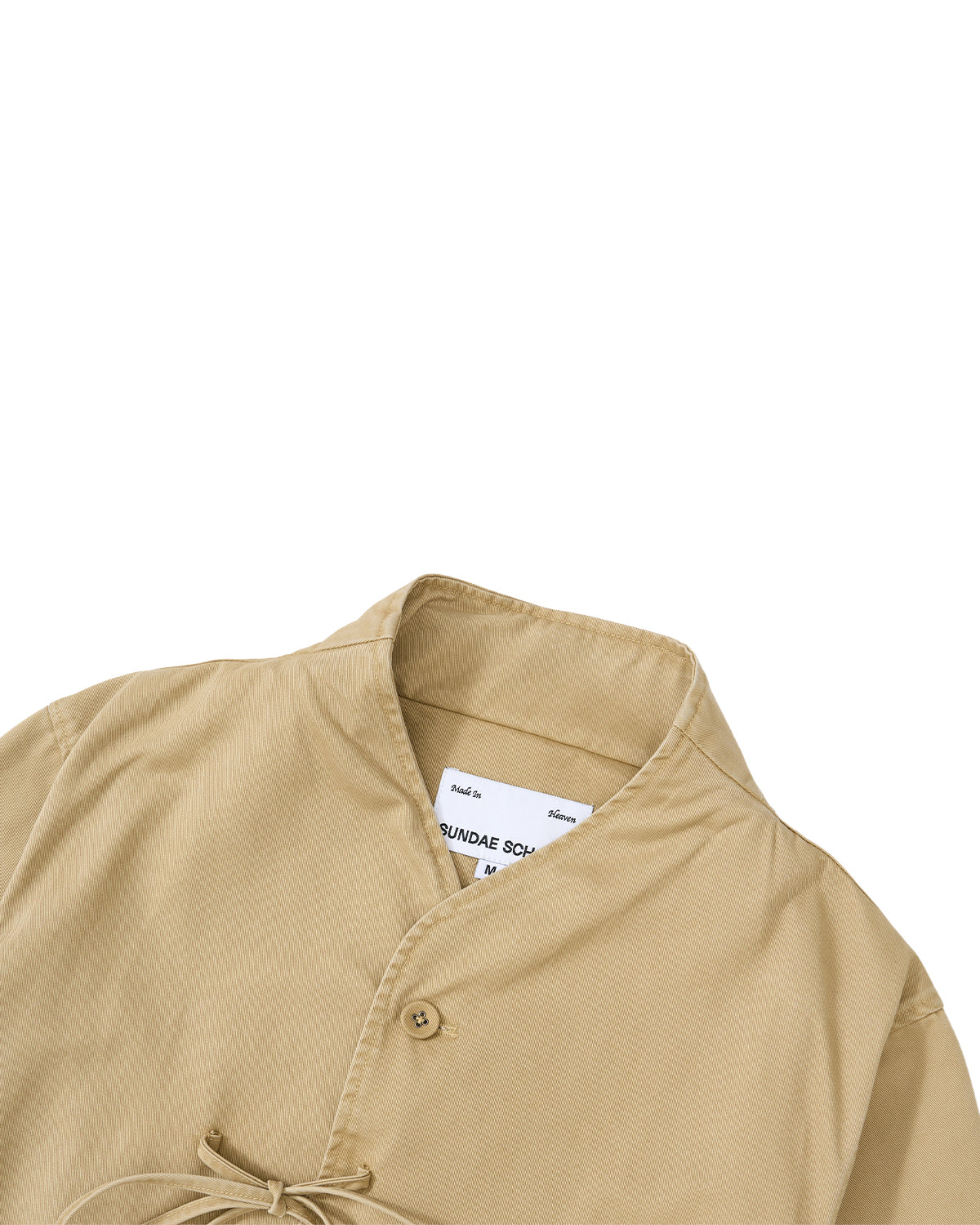 The TAN JEOGORI TIE JACKET by Sundae School features a beige hue with a monk-inspired mandarin collar, single button closure, and a partially visible inner white label near the neckline—making it perfect for summer suiting.