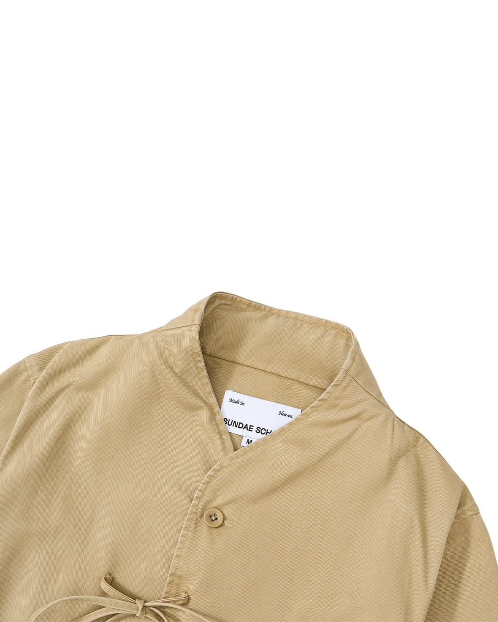 The TAN JEOGORI TIE JACKET by Sundae School features a beige hue with a monk-inspired mandarin collar, single button closure, and a partially visible inner white label near the neckline—making it perfect for summer suiting.