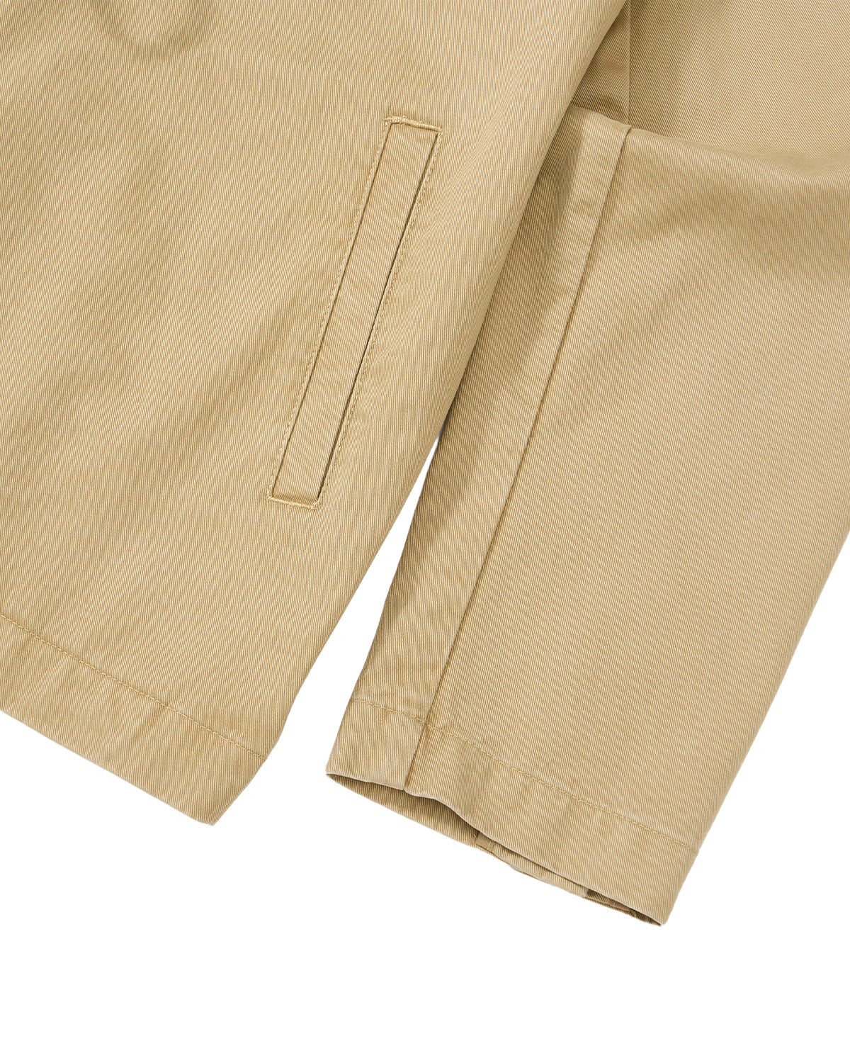 Close-up of the TAN JEOGORI TIE JACKET by Sundae School: a beige sleeve and pocket captured against a white background. The piece showcases meticulous stitching on the pocket and hem, crafted from lightweight cotton—making it an ideal option for summer suiting.