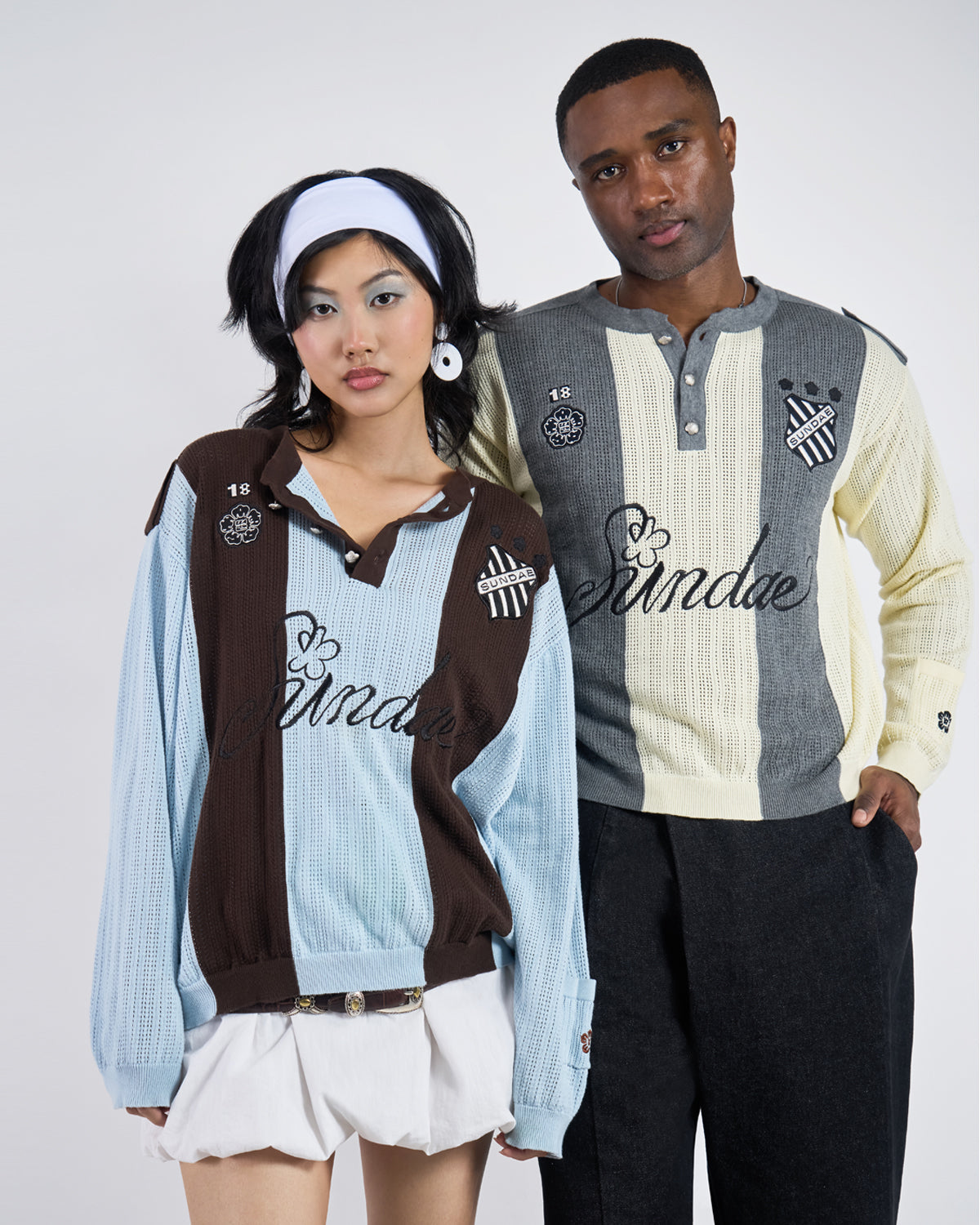 Front view of two models wearing coordinating Sundae Soccer Jersey Knits - female model in Baby Blue Brown Sundae Soccer Jersey Knit with white headband and white mini skirt, male model in Butter Yellow Charcoal colorway with black pants, both featuring 