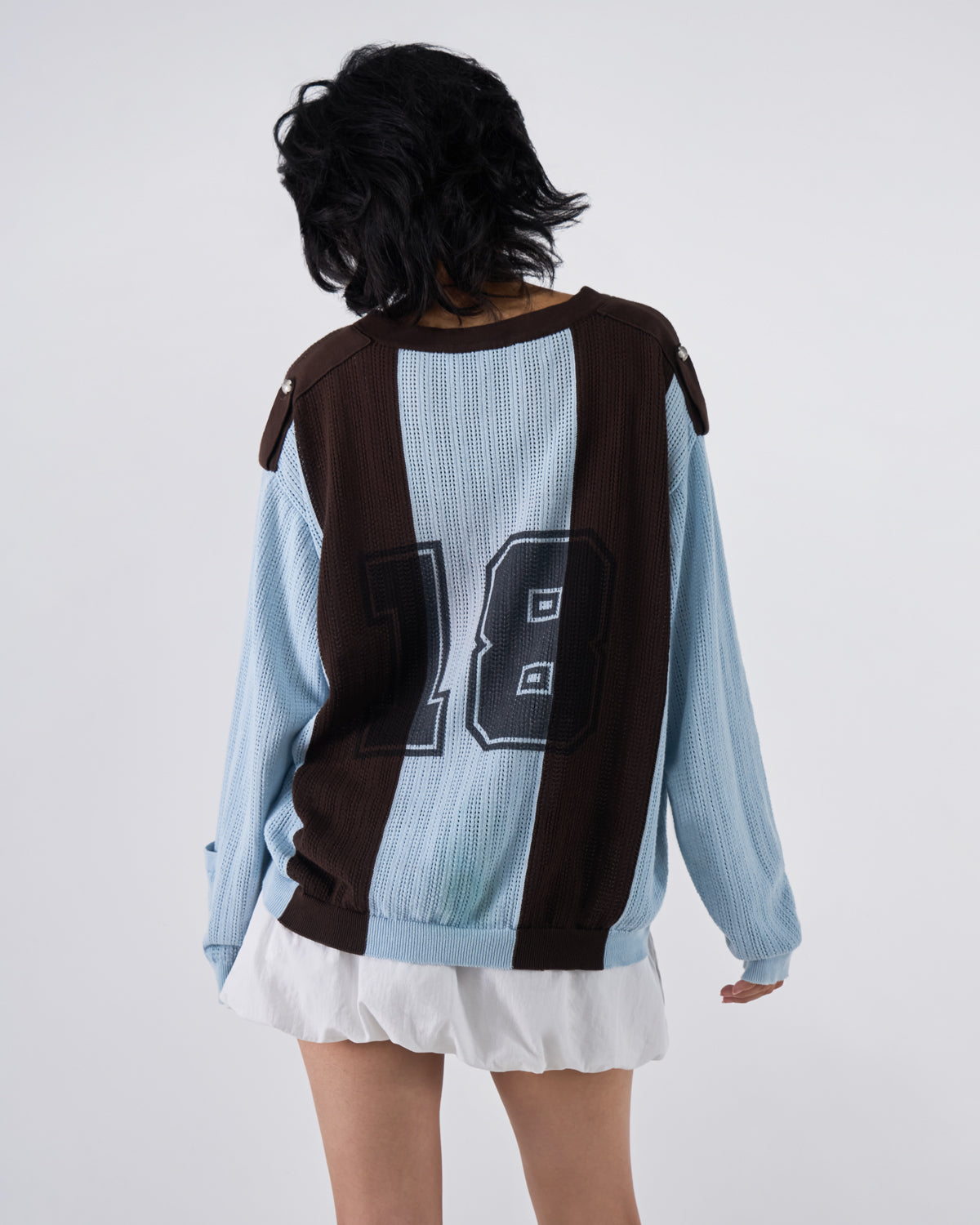 Back view of modeled Baby Blue Brown Sundae Soccer Jersey Knit in dynamic pose with hair in motion, featuring prominent 