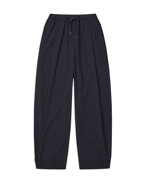 The KIKI DRAWSTRING SLACKS by Sundae School are black, loose-fitting pinstripe sweatpants featuring an elastic drawstring waist, shown flat against a white background. Their wide, straight barrel leg design delivers a relaxed fit for comfortable and effortlessly stylish wear.