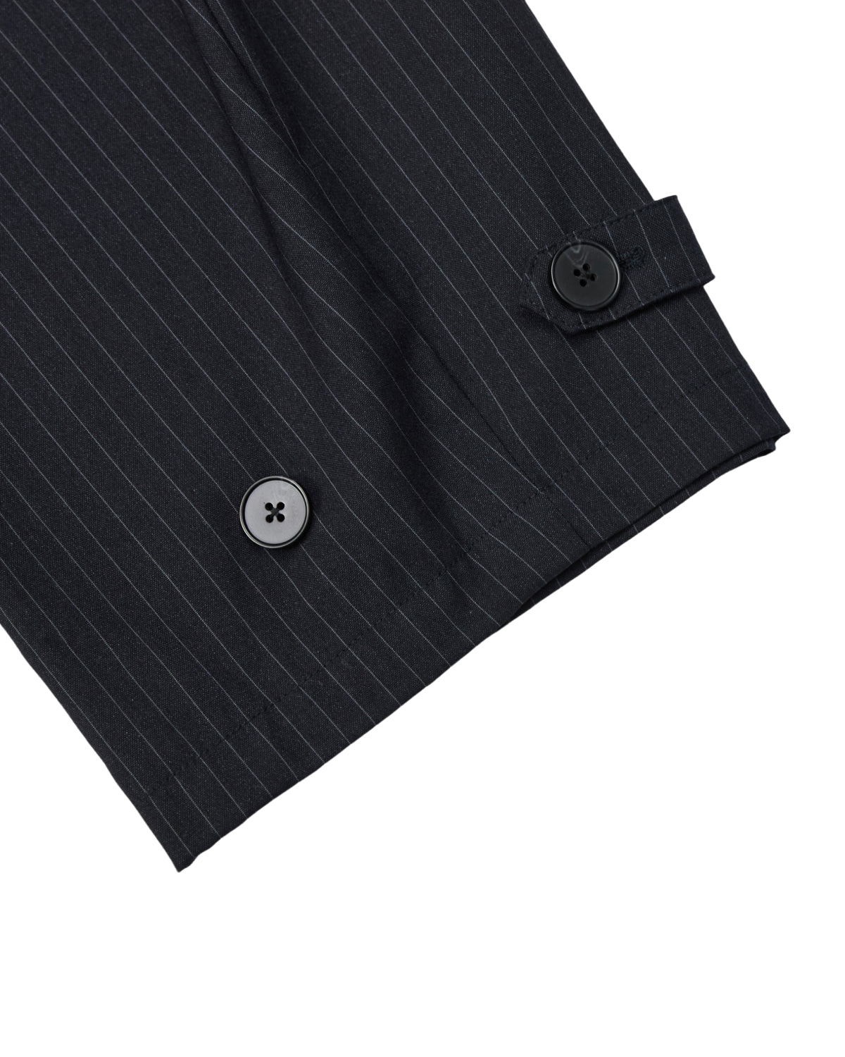 Close-up of a black pinstripe suit sleeve with two black buttons and a decorative tab near the cuff, mirroring the refined details found in Sundae School’s KIKI DRAWSTRING SLACKS—modern pinstripe sweatpants featuring an elastic drawstring waist and a relaxed barrel leg.