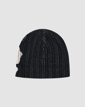 The BLACK DDUL KNIT BEANIE by Sundae School is a black breathable cap featuring a subtle white patch on the left side, shown against a plain light gray background.