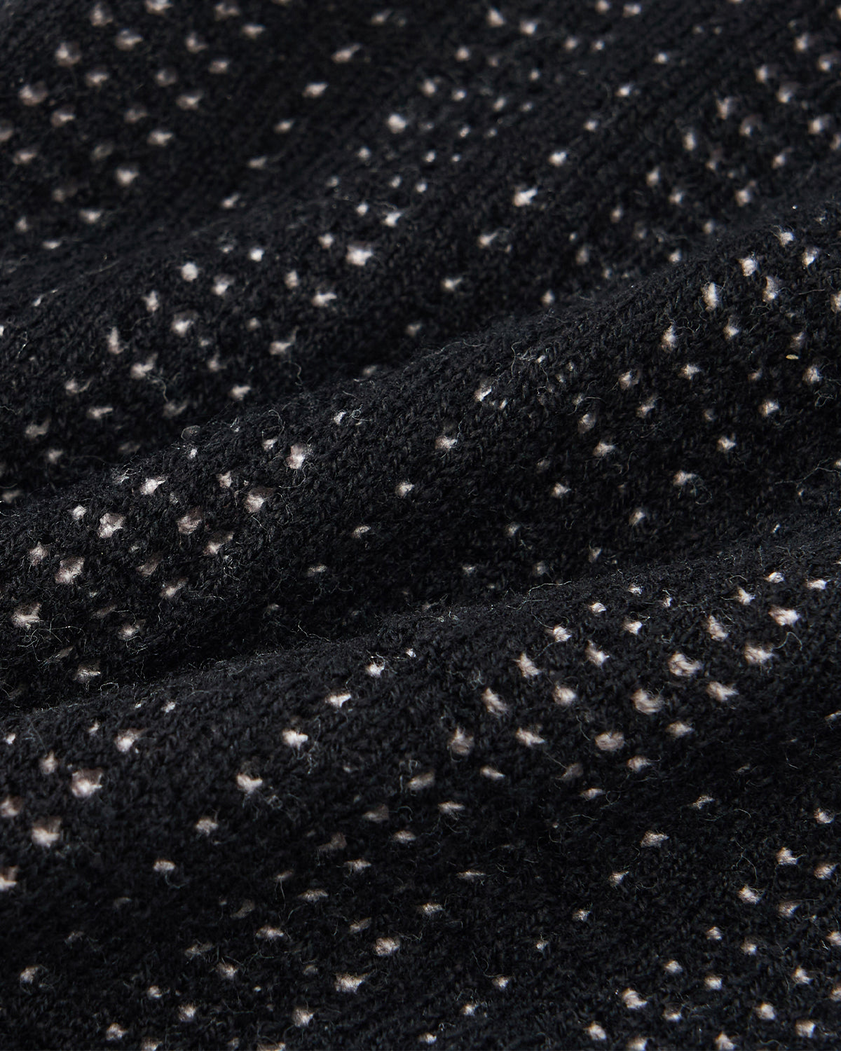 Close-up of the Sundae School BLACK DDUL KNIT BEANIE, featuring a black breathable ribbed texture with small white dots throughout the pattern.