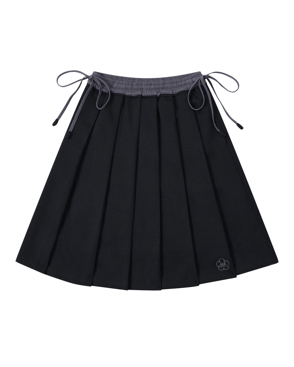 Introducing the BLACK KONA MIDI SKIRT by Sundae School—a black pleated skirt featuring a gray waistband and adjustable side ties. A small embroidered flower accent decorates one corner. The skirt is displayed laid flat against a white background.