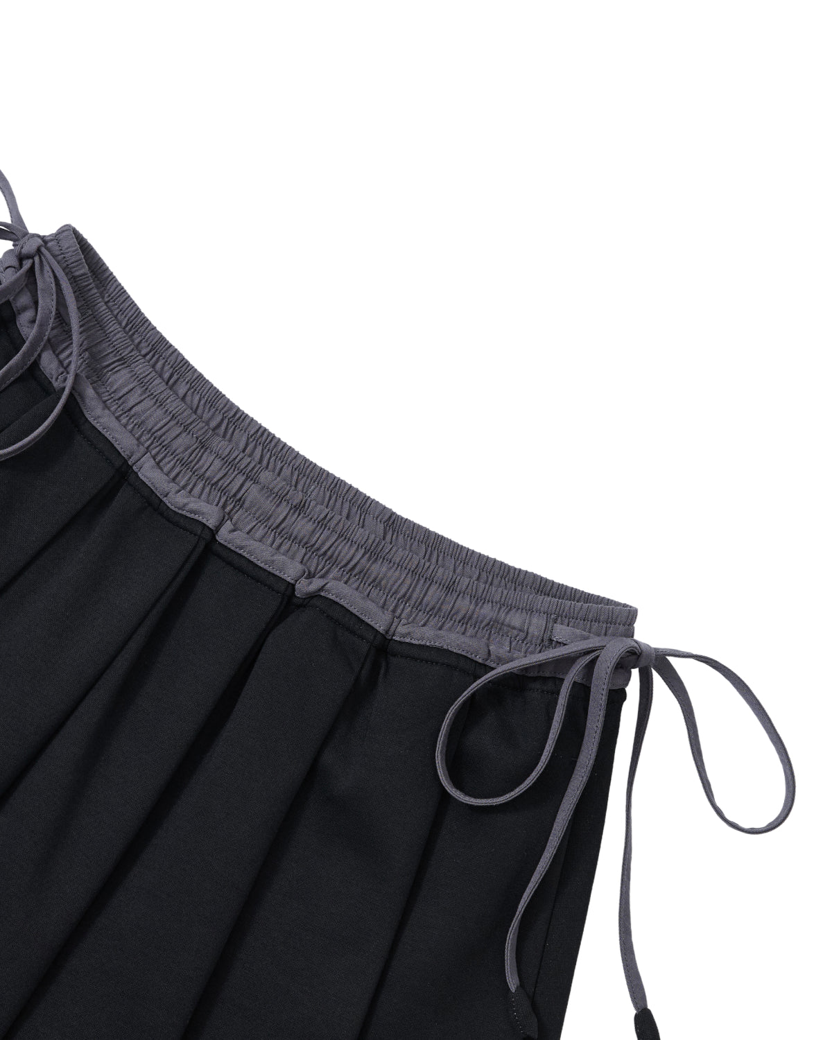 The BLACK KONA MIDI SKIRT by Sundae School features a pleated black fabric with a gray elastic waistband and two gray drawstrings, shown against a white background. The material appears soft to the touch.