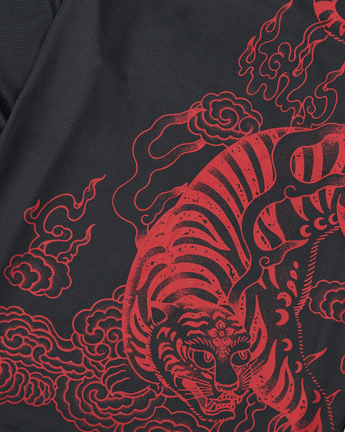 A close-up of a red, stylized tiger amid swirling clouds, printed on dark fabric. Bold lines and fine details evoke traditional Asian art, perfect for the KOREATOWN FOOTBALL JERSEY by Sundae School inspired by Korean graphics.