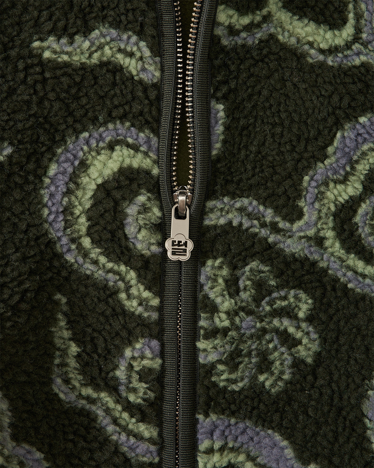 Close-up detail of the zipper of the Kloud Fleece  showing the Sundae School branded zipper.