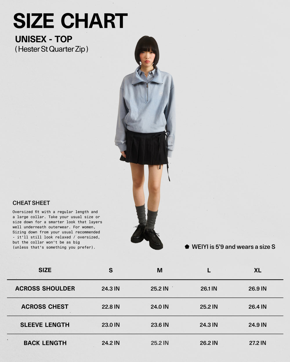 A person wearing the Sundae School SKY BLUE HESTER QUARTER ZIP—a light blue oversized quarter zip hoodie with a funnel neck collar—paired with a black skirt, gray socks, and black shoes stands in front of a size chart for the unisex vintage cotton pullover sweatshirt, which displays measurements for sizes S to XL.