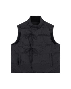 The BLACK MOMO REVERSIBLE FLEECE VEST by Sundae School is a sleeveless black quilted vest featuring a mandarin collar, front tie closures, large patch pockets, and a subtle floral stitching pattern. The vest is displayed laid flat on a white background.