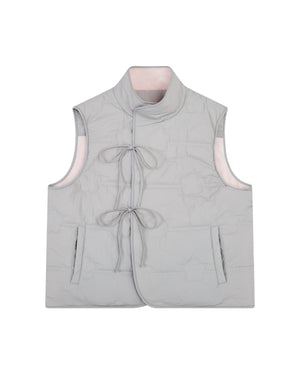 The BABY PINK MOMO REVERSIBLE FLEECE VEST by Sundae School features a light gray, sleeveless quilted exterior with two front pockets, a mandarin collar, and two front ties for closure. The vest is reversible, revealing a soft light pink interior lining.