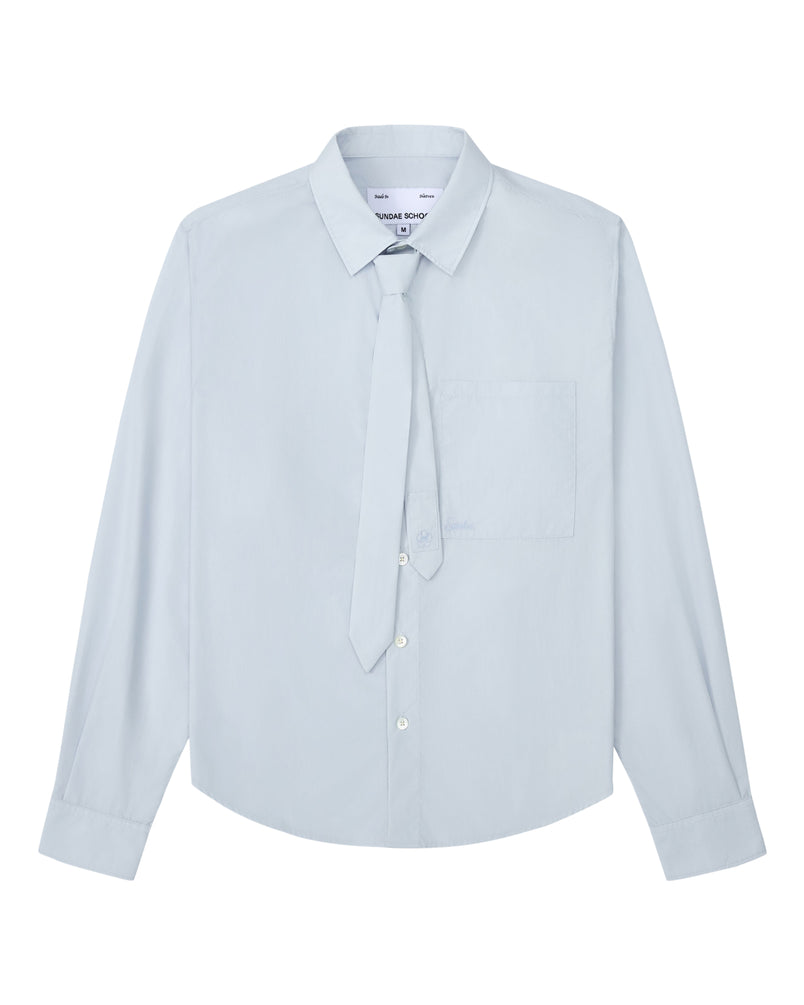 The NECKTIE SHIRT by Sundae School is a light blue long-sleeve poplin shirt featuring a pointed collar, removable matching loose necktie, relaxed fit, and a front left stash pocket. Displayed on a white background.