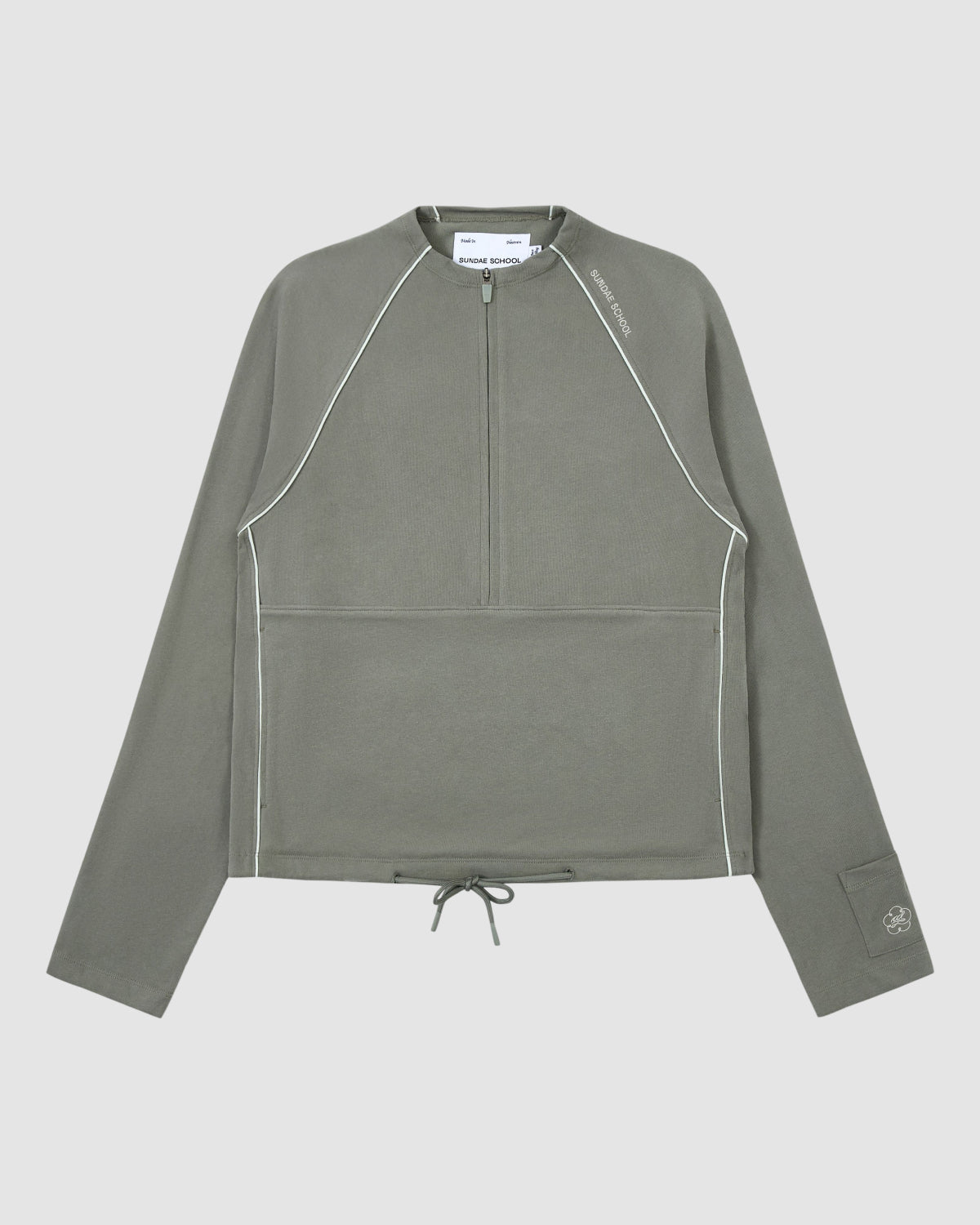 The Sundae School Khaki Office Quarter Zip is a cotton jersey pullover in olive green with white piping, ribbed texture, quarter-zip front, drawstring hem, left sleeve logo, stash pocket, and modern minimalist design.