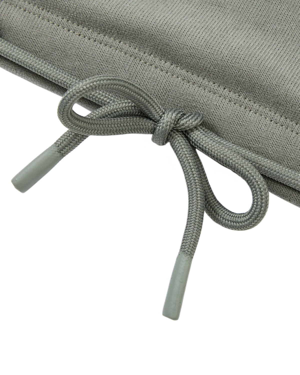Close-up of the KHAKI OFFICE QUARTER ZIP by Sundae School, featuring a grey cotton jersey drawstring tied in a bow with plastic tips, set against a matching grey fabric background.