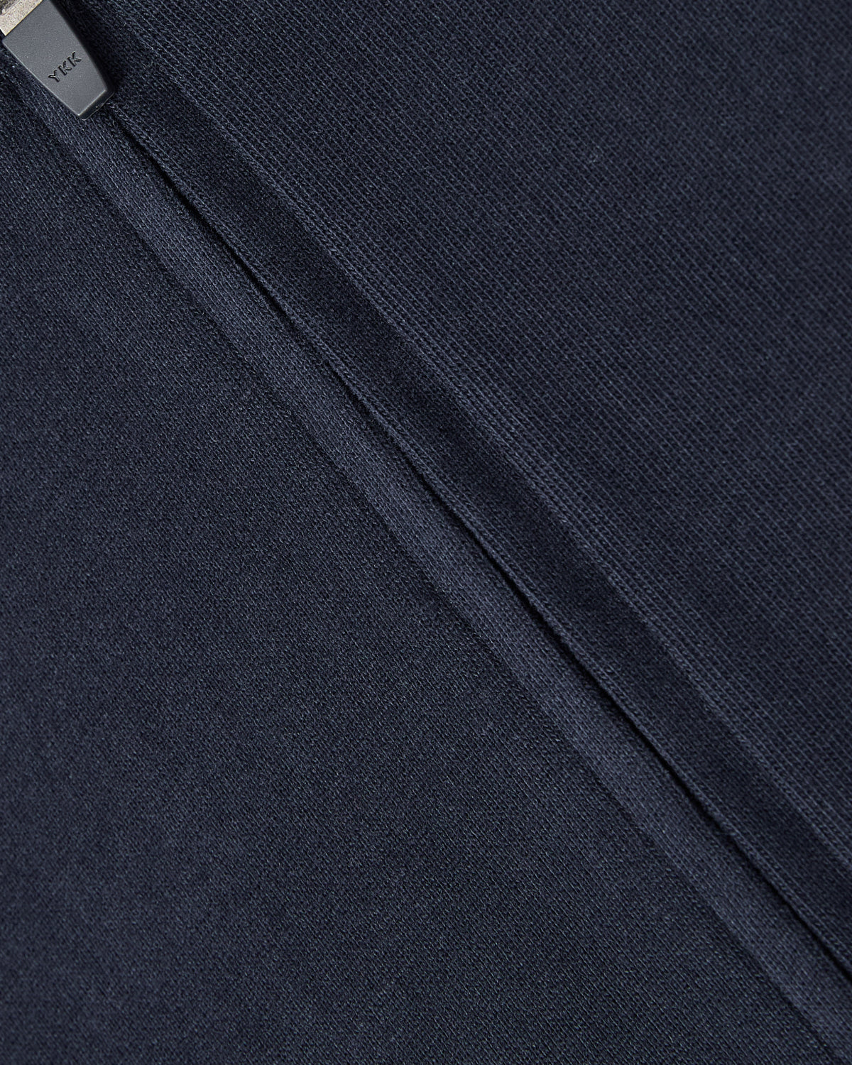 Close-up of Sundae School’s NAVY OFFICE QUARTER ZIP, featuring soft, slightly ribbed navy cotton jersey with a visible seam and YKK zipper, offering comfort and everyday style in a quarter-zip design.